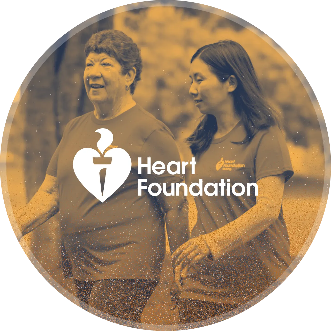Two women walk through a park for heart health, wearing Heart Foundation tees.